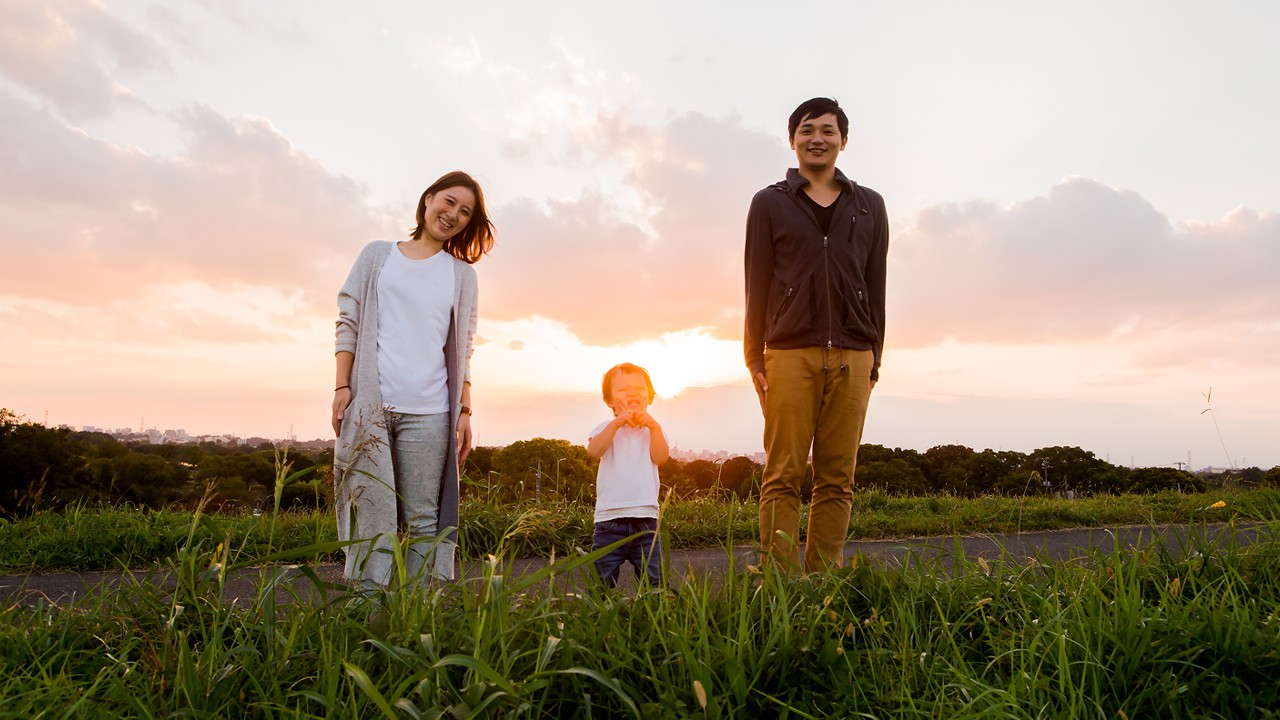 Family standing outside with the sunset; image used for HSBC insurance.