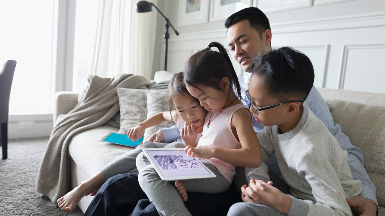 父親與三個小孩在沙發上看書；圖片使用於滙豐無障礙公開資訊專區新臺幣存款利率頁面。