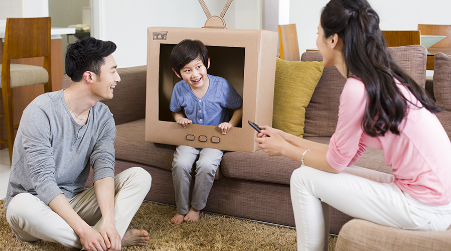 一家人在玩紙板電視遊戲；圖片使用於滙豐貸款主題文章裝潢打造夢幻家居。