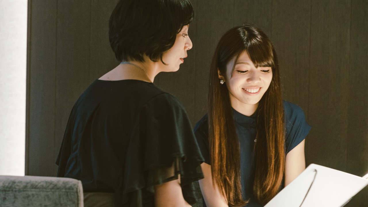 A woman is reviewing her financial portfolio with her financial advisor; image used for unit trust.