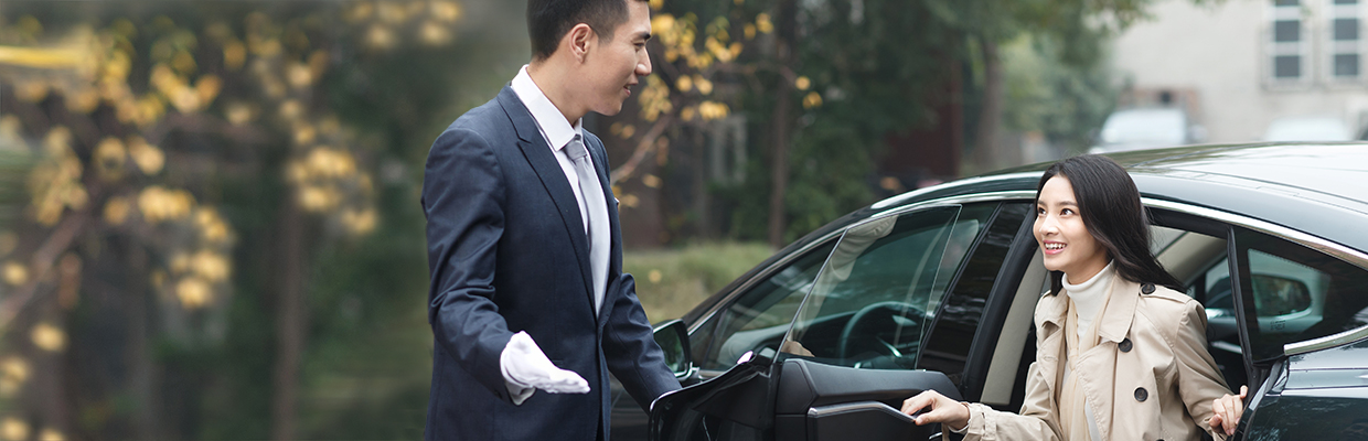A man opens car door for a woman; Image used for HSBC free airport transfers page.