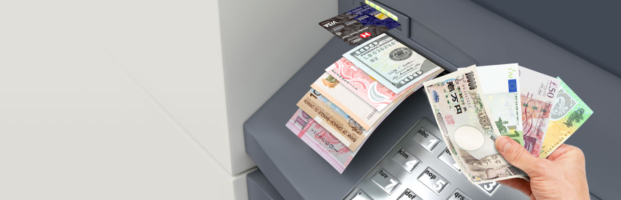 Withdrawing multiple currency banknotes from an ATM; imaged used for HSBC Everyday Global Visa Debit Card page.