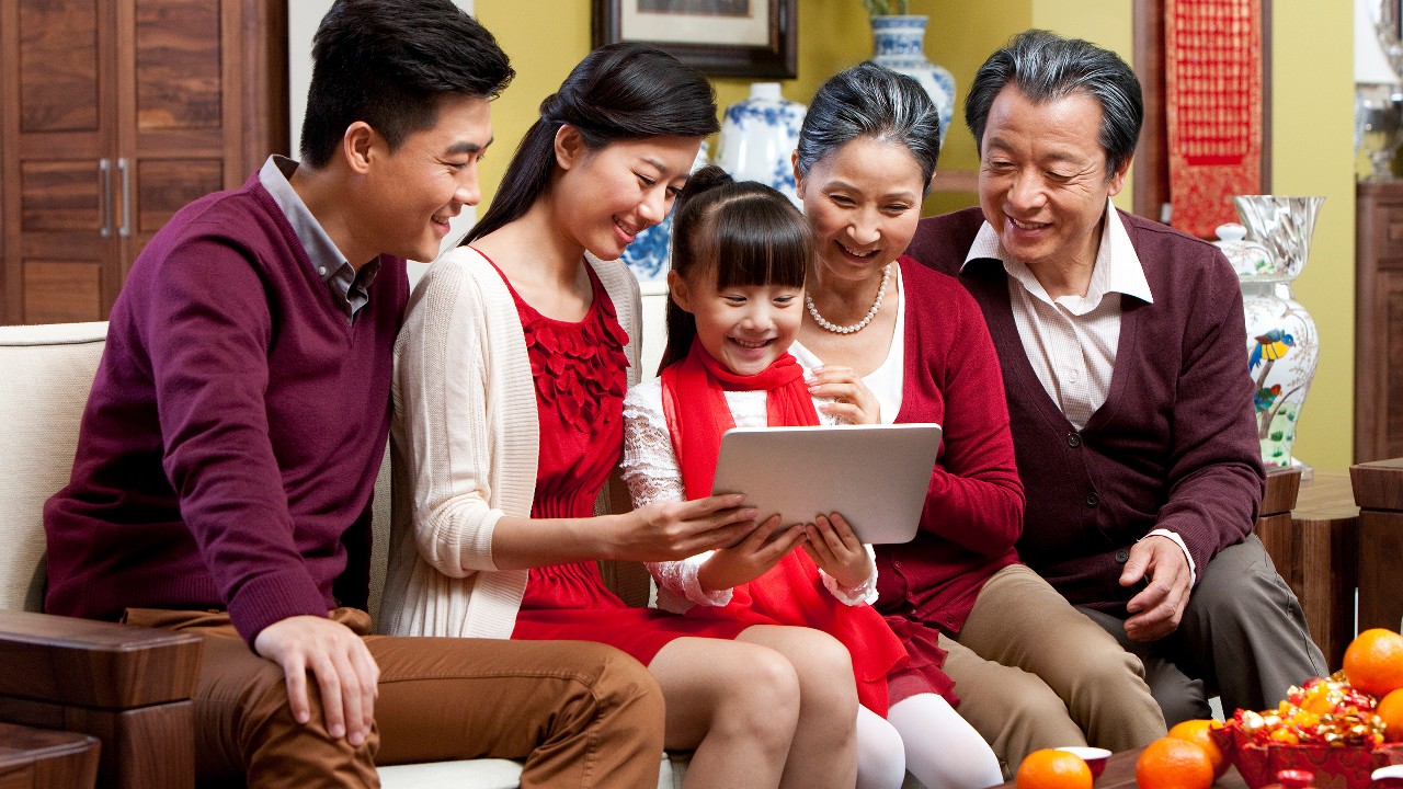 A family is watching a tablet together; image used for HSBC online banking.