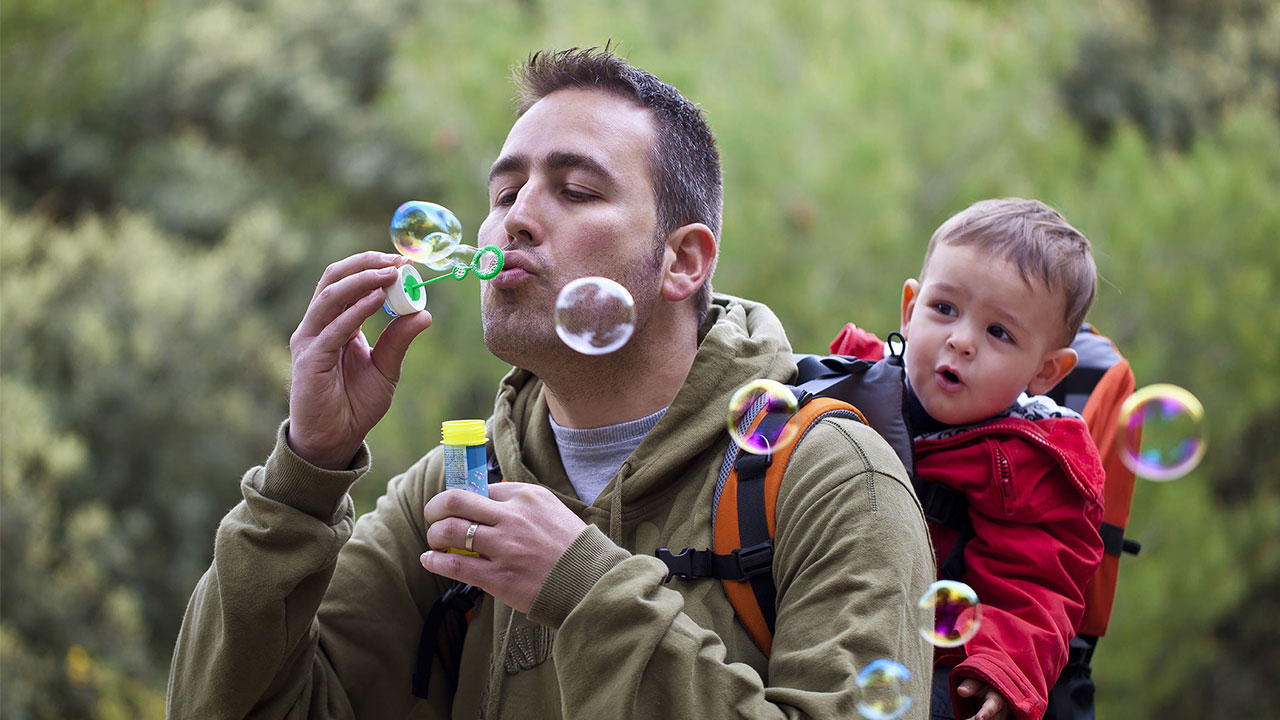 一位父親和他的孩子玩吹泡泡；圖片使用於滙豐無障礙公開資訊專區運籌理財頁面。
